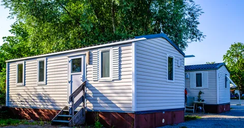 A row of white modular homes under a blue sky