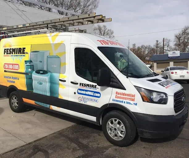 A Fesmire Heating & Air Conditioning service van, wrapped in the company’s sun logo and phone number
